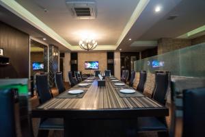 a long dining room with a long table and chairs at Kiss Gardenhome Chic Hotel in Hat Yai
