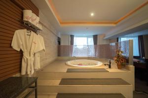 Kiss Gardenhome Chic Hotel في هات ياي: حمام كبير مع حوض ومغسلة