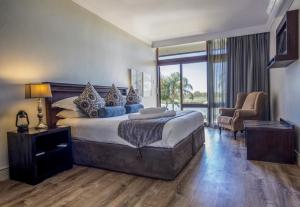 a bedroom with a large bed and a living room at River Place Manor in Upington
