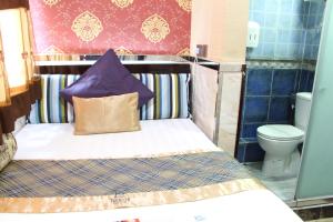 香港的住宿－Temple Street Hotel，一张带紫色枕头的小床