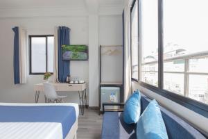 a hotel room with a bed and a desk and window at Spotlight Hotel in Ho Chi Minh City