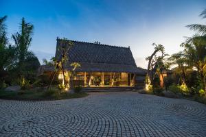 a house with a cobblestone driveway in front of a building at Arya Villas Ubud in Ubud