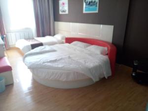 a bedroom with a red and white bed in a room at Thank Inn Chain Hotel Shandong Zichuan Songlin West Road in Zibo