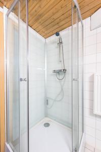 La salle de bains est pourvue d'une douche avec une porte en verre. dans l'établissement Holma Stångenäs Golf Bed & Breakfast, à Brastad