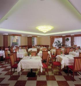 un restaurant avec des tables et des chaises et un lustre dans l'établissement Hotel Olivo, à Arco