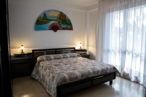 マリーナ・ディ・ラグーザにあるVilletta a Marina di Ragusaのベッドルーム1室(ベッド1台付)、窓(カーテン付)