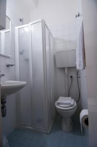 a bathroom with a toilet and a shower and a sink at Hotel Savina in Rimini
