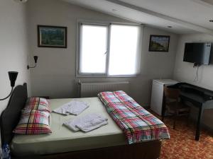 a bedroom with a bed and a desk and a window at Sakran Hotel in Yenişakran