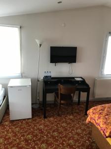 a room with a desk and a flat screen tv at Sakran Hotel in Yenişakran