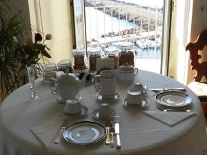 ガリポリにあるPalazzo De Tomasi B&Bの白いテーブルクロスに皿や調理器具をかけたテーブル