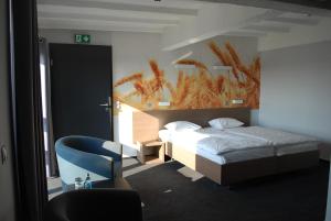 a bedroom with a bed and a blue chair at Stary Młyn in Strzelce Opolskie