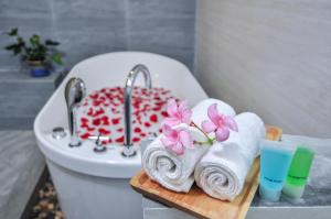 فندق وسبا تريتون بيتش في مافوشي: حمام مع حوض ومنشفة على لوح تقطيع