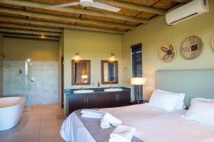 Un dormitorio con una cama y dos lavabos y una bañera. en Mjejane Bush Camp by Dream Resorts, en Hectorspruit 146 fotos más