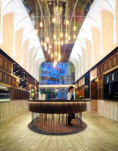 a person standing at a bar in a large building at Bespoke Hotel Puchong in Puchong