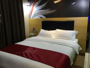 uma cama grande num quarto de hotel com aumedumedumed em Thank Inn Chain Hotel Hunan Changsha Furong District Railway Station em Changsha