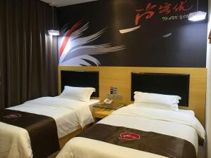 a hotel room with two beds and a sign on the wall at Thank Inn Chain Hotel Hunan Changsha Furong District Railway Station in Changsha