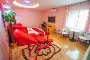 a living room with red chairs and a table at Thank Inn Chain Hotel Hunan Changsha Furong District Railway Station in Changsha