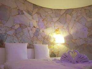 ニデッケンにあるVilla Sandroseの石壁のベッドルーム(ベッド1台、ランプ付)