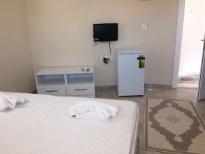 a room with two beds and a small refrigerator at VİRA HOTEL DALYAN in Dalyan