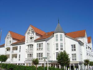 een groot wit gebouw met een rood dak bij Haus Baltic Sellin by Rujana in Ostseebad Sellin