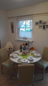 - une table à manger avec une table et des chaises blanches dans l'établissement Ferienwohnung 15 in Koserow, à Ostseebad Koserow