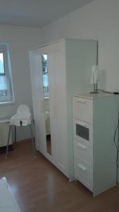 Cette chambre comprend une armoire blanche et un miroir. dans l'établissement Ferienwohnung 15 in Koserow, à Ostseebad Koserow