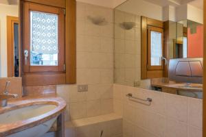 a bathroom with a sink and a television at Cà Nicoletto by Venicevillas, Lido in Venice-Lido +29 photos