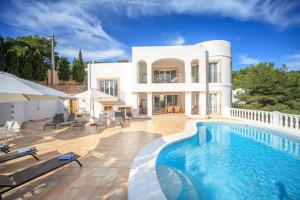 une villa avec une piscine en face d'une maison dans l'établissement Villa Sa Seni, à Cala Llonga