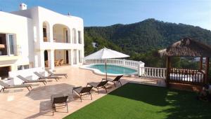 a patio with chairs and a pool and a house at Villa Sa Seni in Cala Llonga