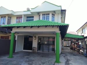 a house with green columns in front of it at Pan Homestay in Kuantan