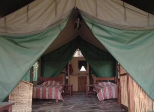 ein grünes und braunes Zelt mit Stühlen und Tischen in der Unterkunft Nsobe Game Camp in Masaiti