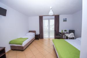 a hotel room with two beds and a table with a desk at Willa Północna in Karwia
