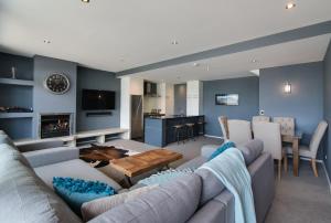a living room with a couch and a table at Villa Two at Vailmont Queenstown in Queenstown