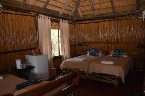 a room with two beds in a wooden room at Moholoholo Mountain View in Hoedspruit