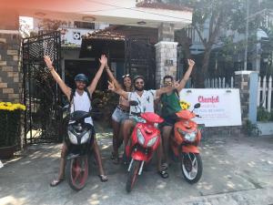 un gruppo di quattro persone seduti su scooter di Cheerful Hoi An Hostel a Hoi An
