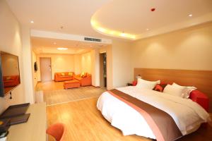 1 dormitorio con 1 cama grande y sala de estar en JUNYI Hotel Hebei Shijiazhuang Pingshan Town Wanshou Road, en Pingshan