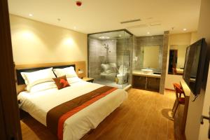 1 dormitorio con 1 cama grande y baño en JUNYI Hotel Hebei Shijiazhuang Pingshan Town Wanshou Road, en Pingshan