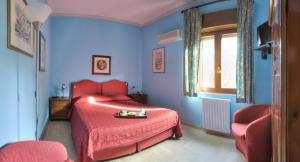 a blue bedroom with a red bed with a red blanket at Agriturismo Al Poggetto in Piana degli Albanesi +56 photos