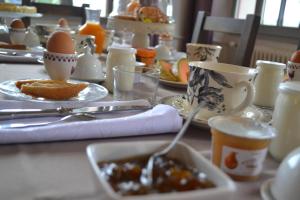 a table with a plate of food and eggs and coffee at Les Terrasses De Bessou in Clermont-Dessous