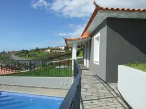 a villa with a pool and a view at Paraiso das Flores in Estreito da Calheta