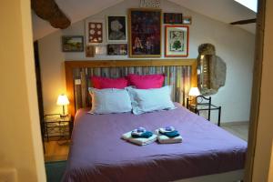a bedroom with a bed with two slippers on it at Les Terrasses De Bessou in Clermont-Dessous