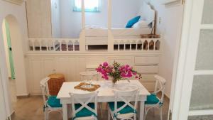 a dining room with a table and chairs and a bed at Amalthia House in Arkasa +10 photos