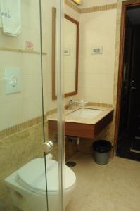 a bathroom with a toilet and a sink at Ponnis Grand Inn in Chennai