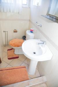 a bathroom with a white sink and a toilet at Ridge Over Suite in Accra