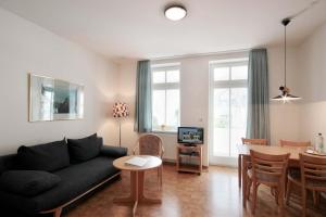 a living room with a black couch and a table at Villa Hans by Rujana in Binz