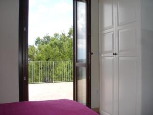 a bedroom with a door open to a balcony at Casa Le Querce in Ogliastro Cilento