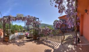 a garden with a gate with purple wisterias at Agriturismo Al Poggetto in Piana degli Albanesi