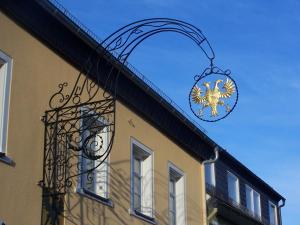 a building with a sign hanging off the side of it at Garni Hotel Post in Weißenstadt