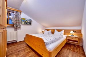 a bedroom with a wooden bed and a window at Gästehaus Anneliese in Wallgau