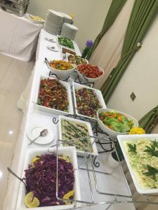 um buffet de saladas e tigelas de comida numa mesa em Queen Plaza Hotel em Hebron
